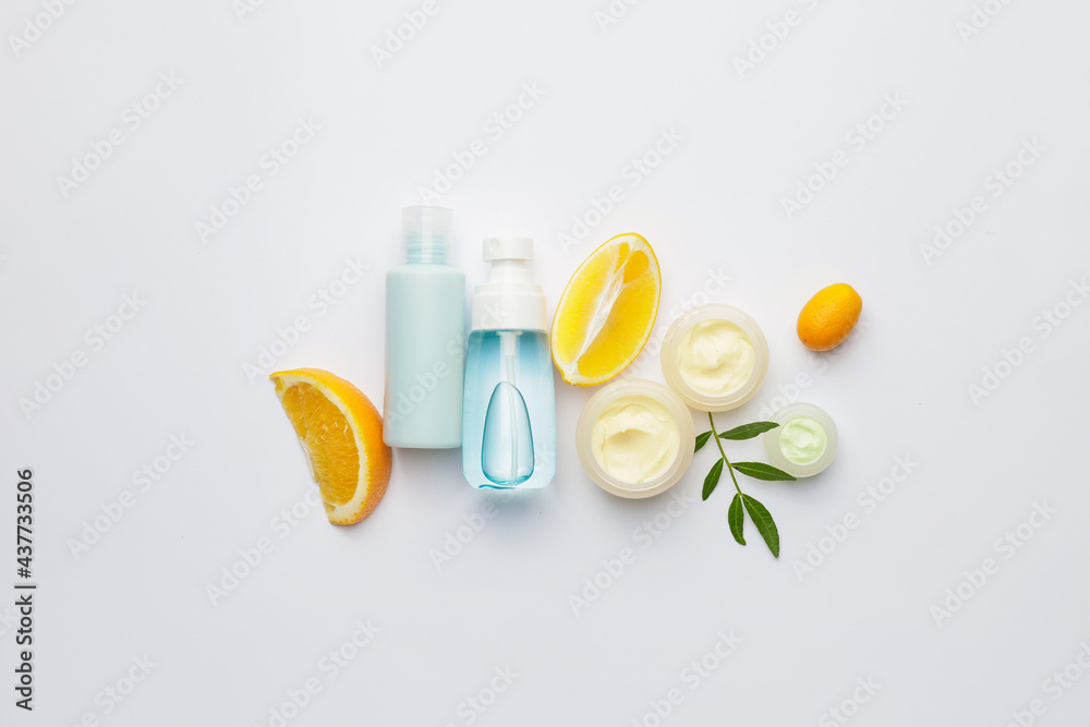 Natural cosmetic products with citrus fruits on white background