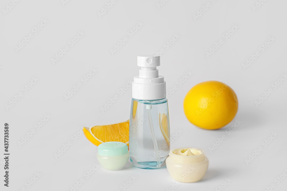 Natural cosmetic products with citrus fruit on grey background