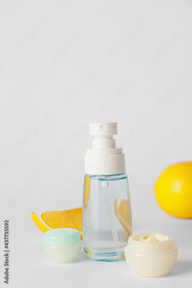 Natural cosmetic products with citrus fruit on grey background