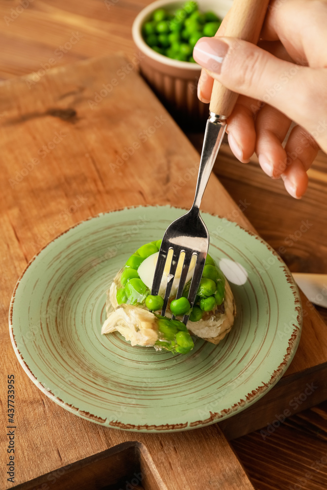 Woman eating tasty aspic from plate