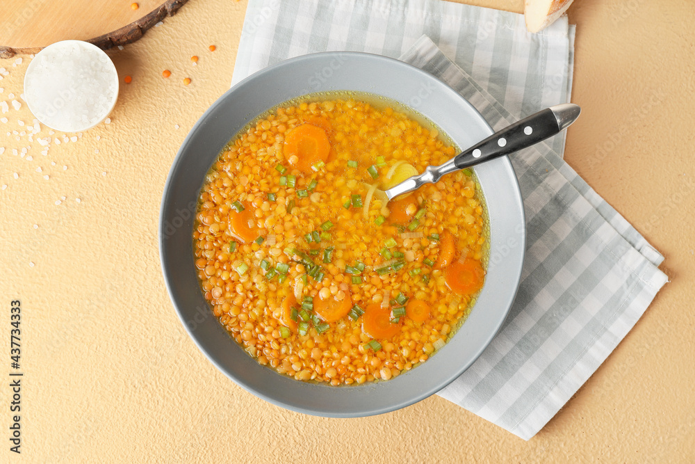 Bowl of tasty lentil soup on color background