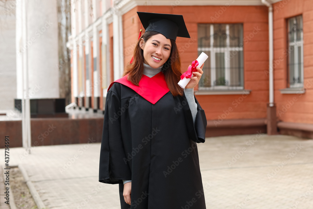 Female student in bachelor robe and with diploma on her graduation day