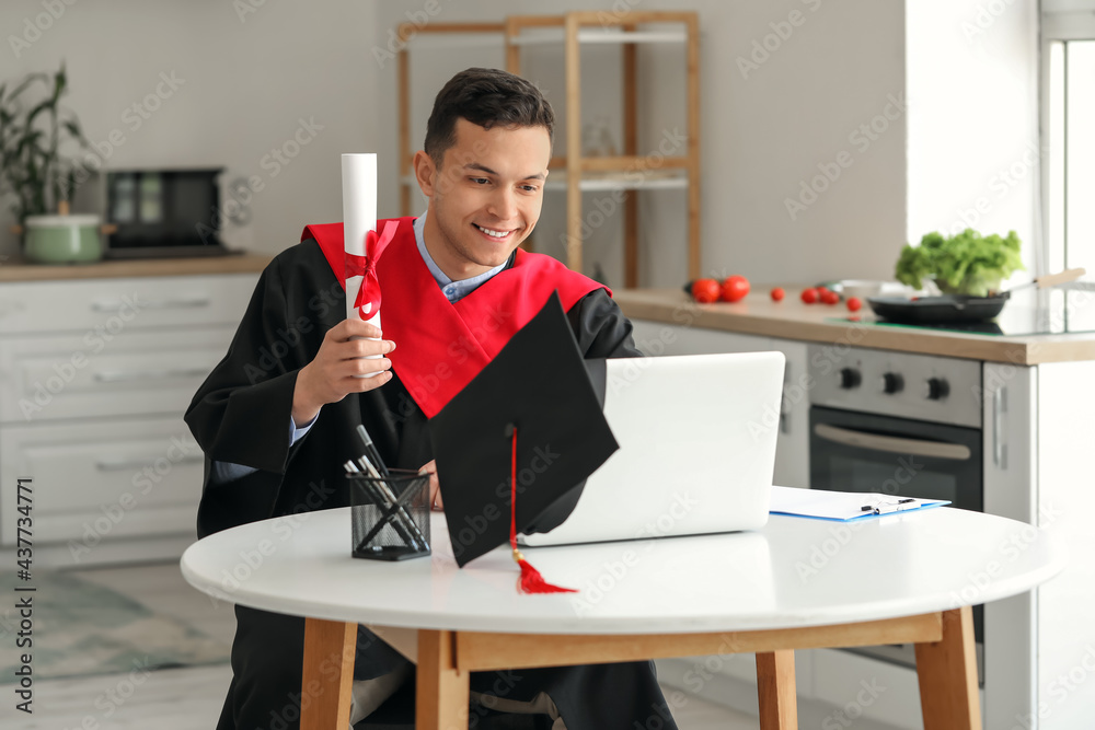 Happy male student on his graduation day at home. Concept of online education