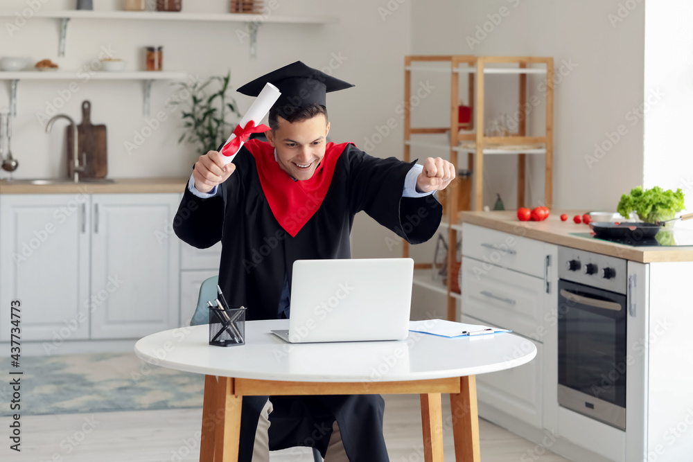 Happy male student on his graduation day at home. Concept of online education