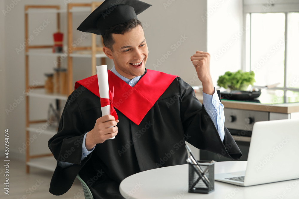 Happy male student on his graduation day at home. Concept of online education