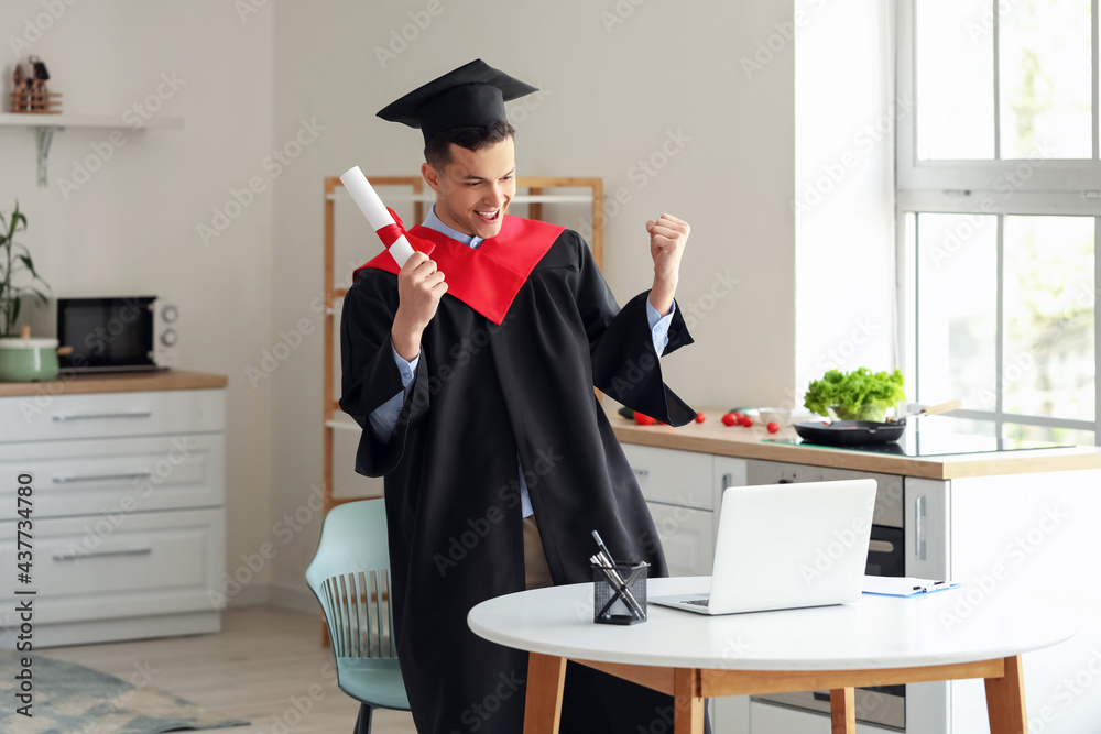 Happy male student on his graduation day at home. Concept of online education