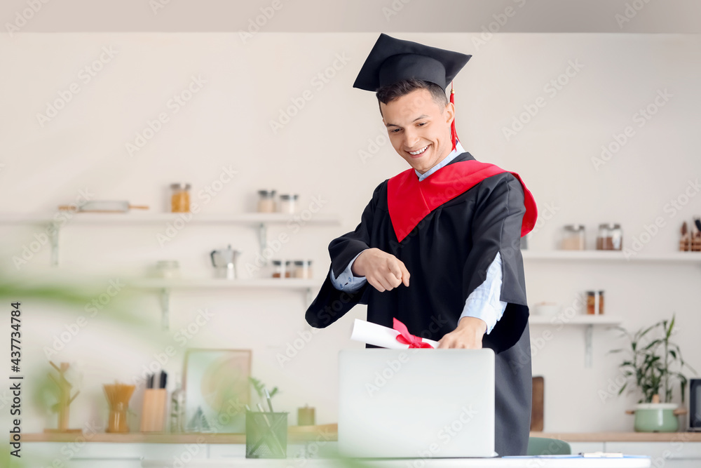 Happy male student on his graduation day at home. Concept of online education