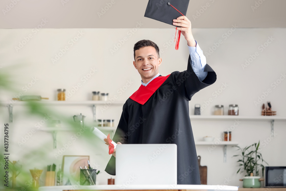 Happy male student on his graduation day at home. Concept of online education