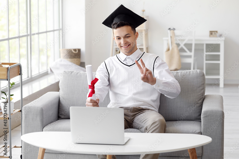 Happy male student on his graduation day at home. Concept of online education