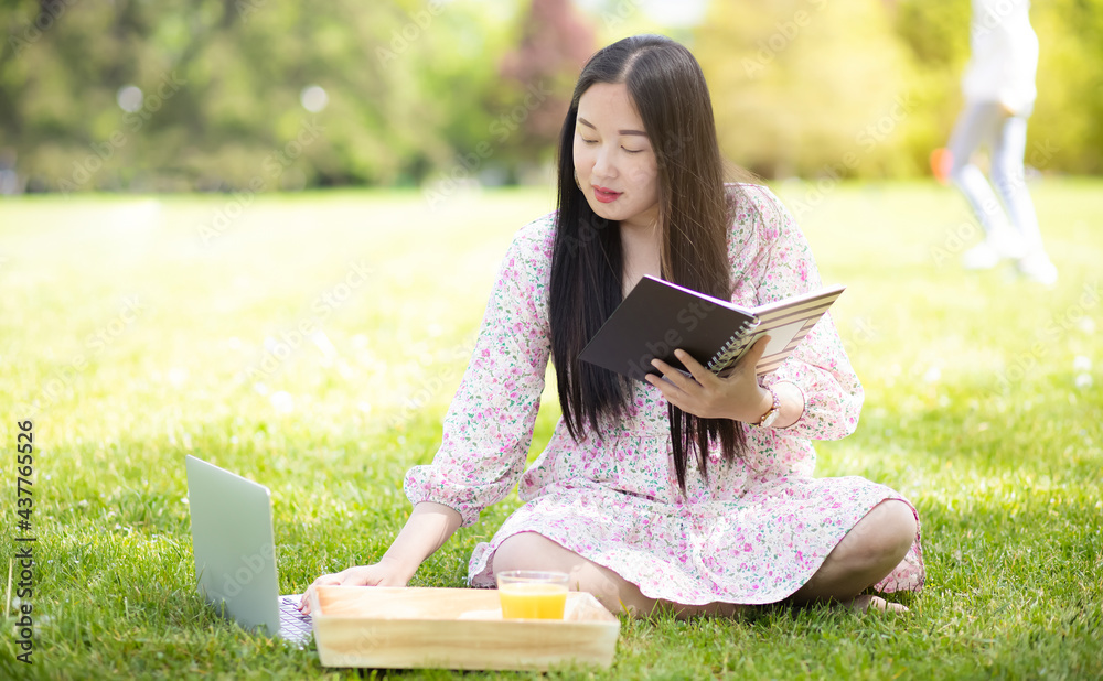 夏天或春天在外面工作和WFH概念，年轻漂亮的亚洲女人读书和