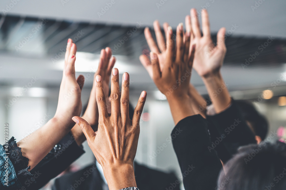 Many happy business people raise hands together with joy and success. Company employee celebrate aft