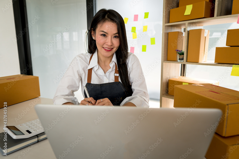 Young smiling beautiful owner asian woman freelance sme business online shopping working on laptop c