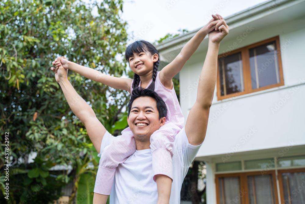 Happy family father with cute daughter play pilot of airplane at home