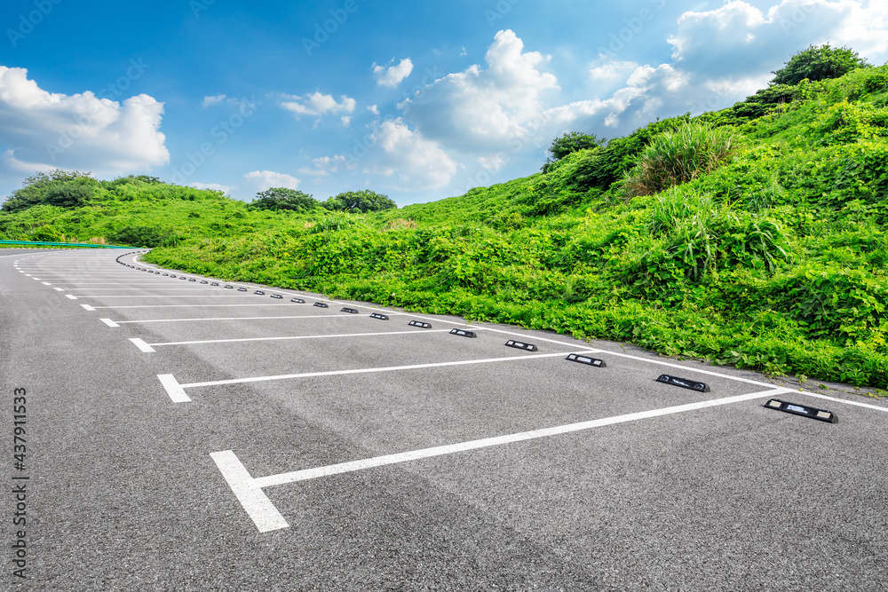 Asphalt parking lot and green mountain nature landscape.