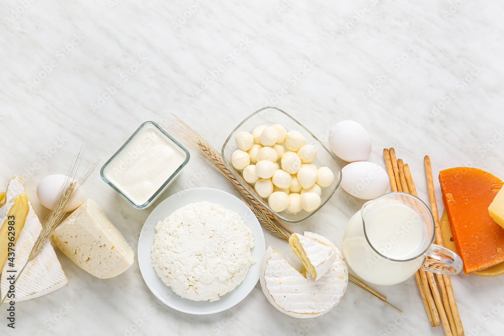 Different dairy products and chicken eggs on light background