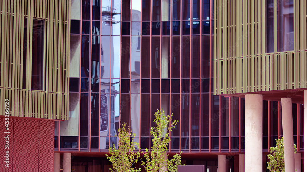 Abstract closeup of the glass-clad facade of a modern building covered in reflective plate glass. Ar