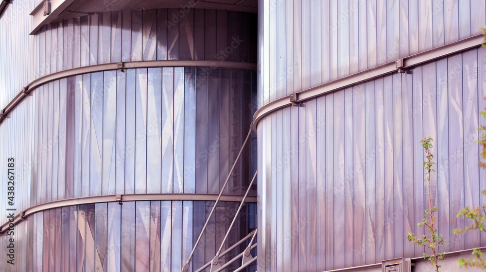 Abstract closeup of the glass-clad facade of a modern building covered in reflective plate glass. Ar