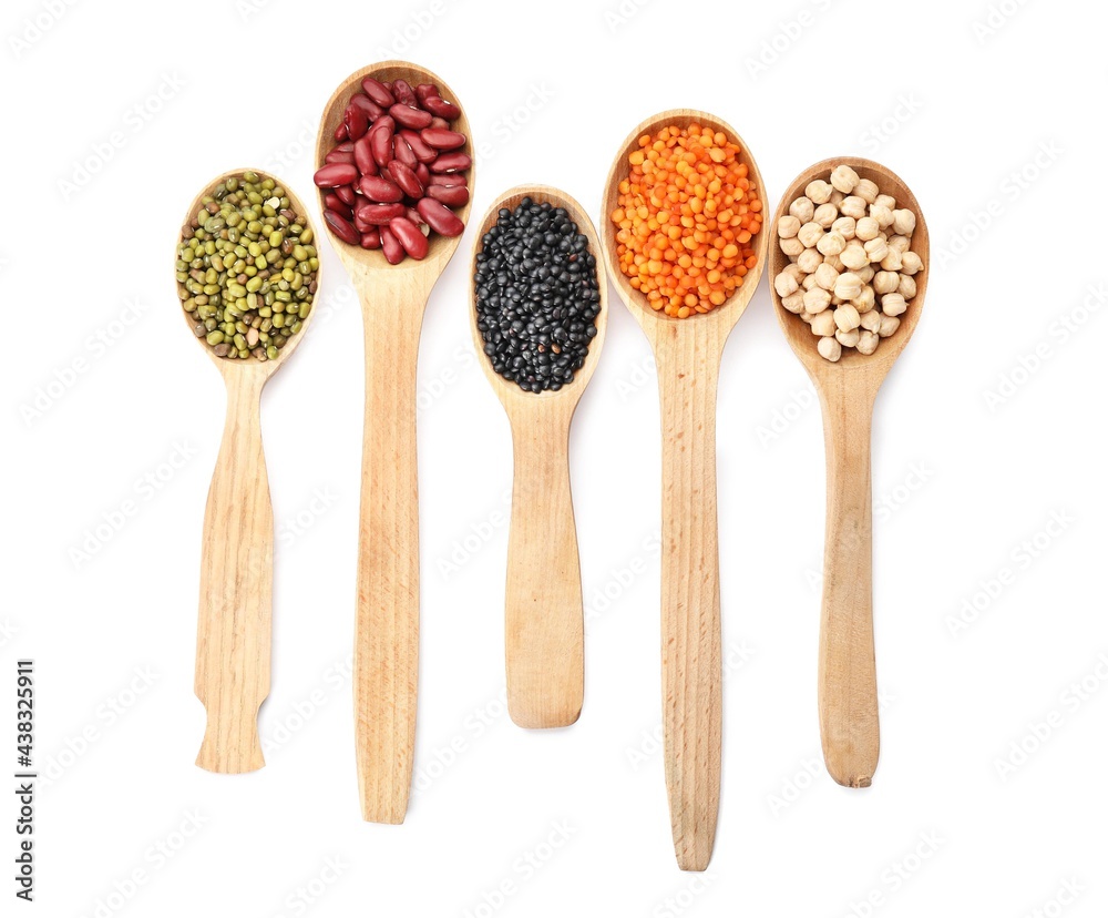 Spoons with different legumes on white background