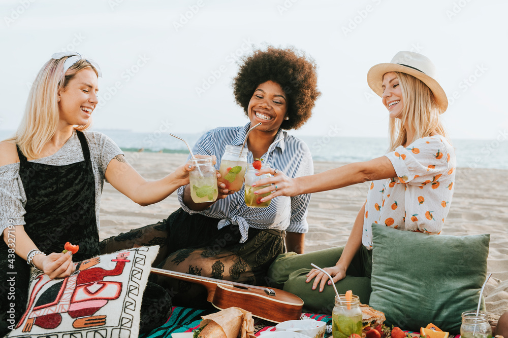 Friends clinking their glasses at a beach party