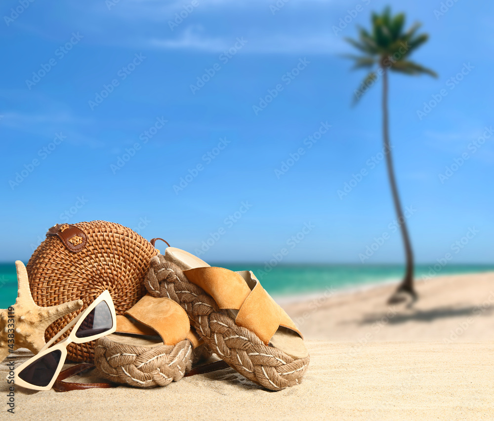 Stylish beach accessories on sand at tropical resort