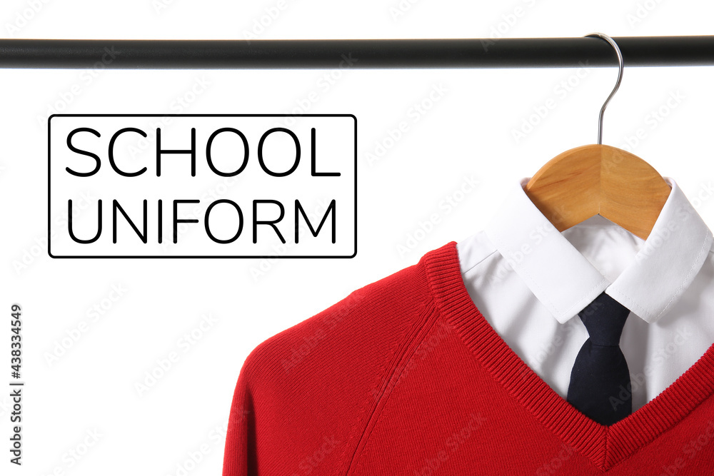 Stylish school uniform hanging on rack against white background