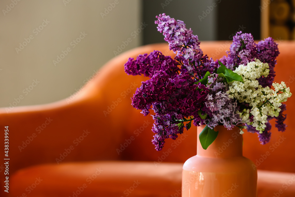 Vase with lilac flowers in room, closeup