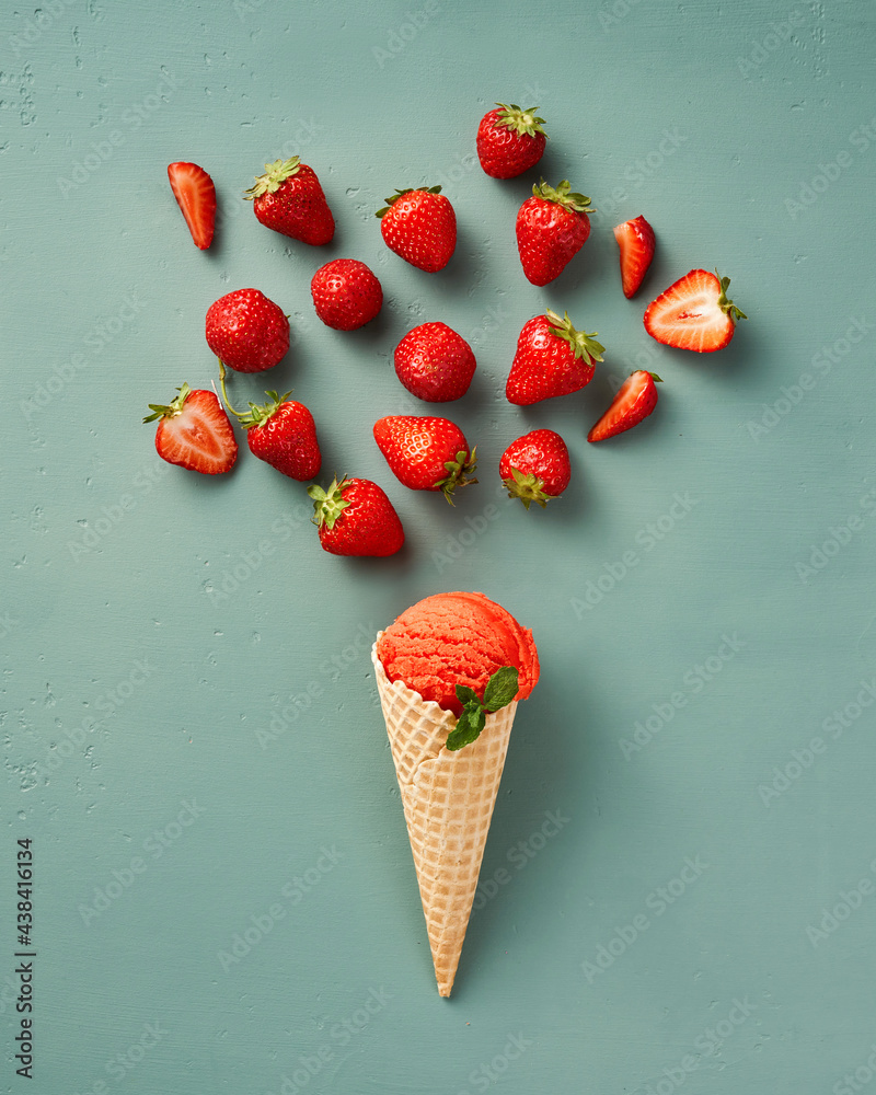 Fresh strawberry ice in cone with strawberries on blue background. Top view italian gelato. Concept 