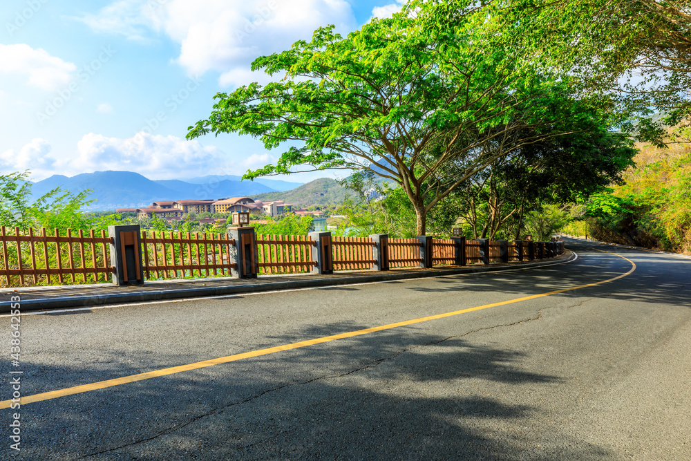 晴朗的日子里，空旷的柏油路和山景。