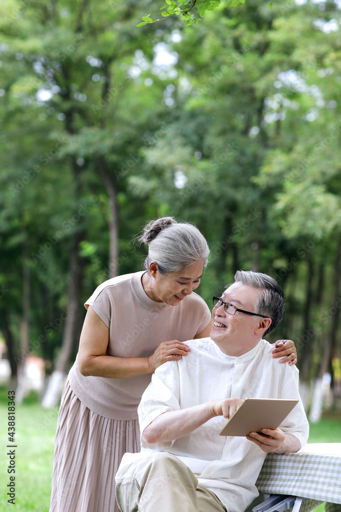 幸福的老年夫妇在户外用平板电脑上网