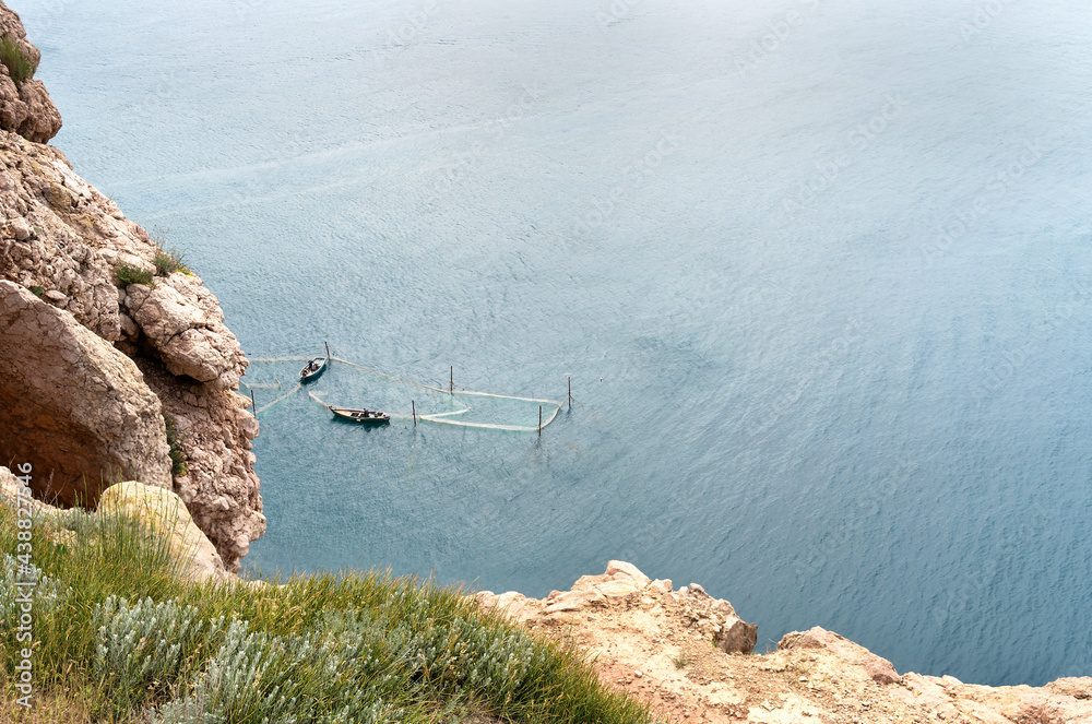 Beautiful seascape from high cliff with two boats and fishing net. Fishing concept.