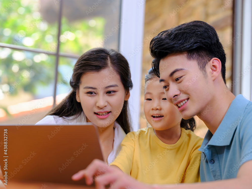 A Happy family of three using laptop