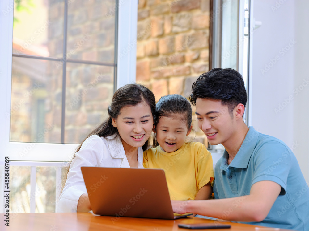 A Happy family of three using laptop