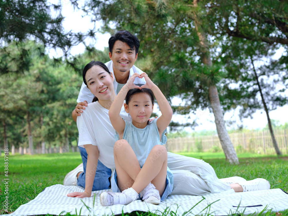 Happy family of three playing in the park