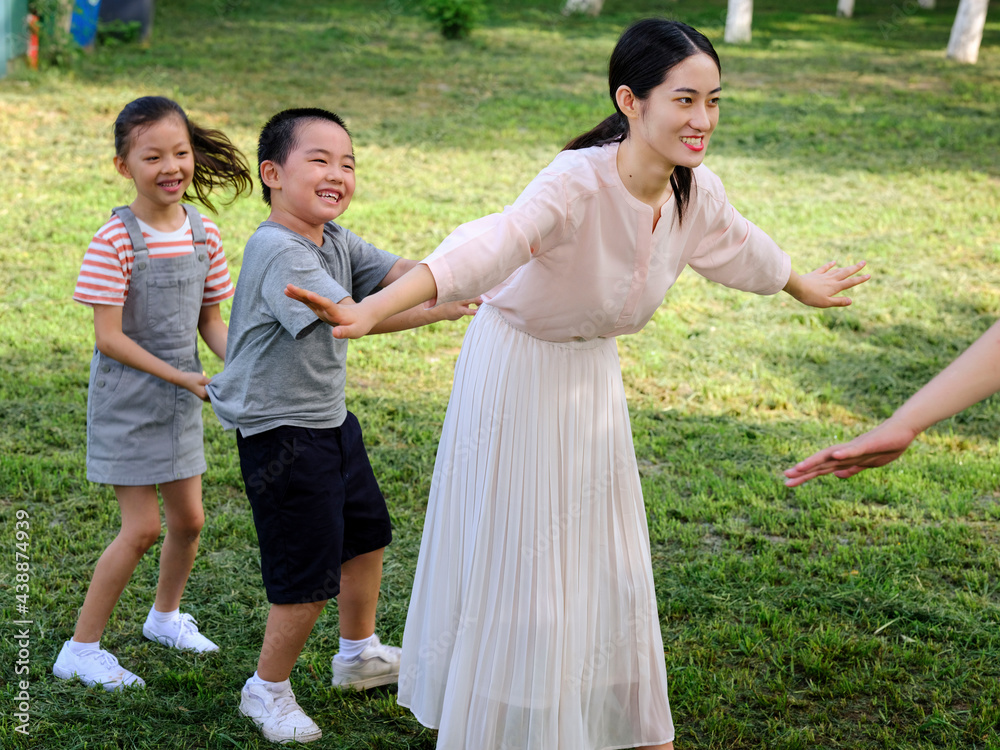 Happy family of four playing in the park