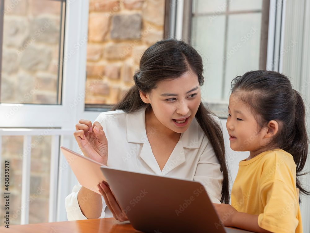 Young Happy mother and daughter use tablet