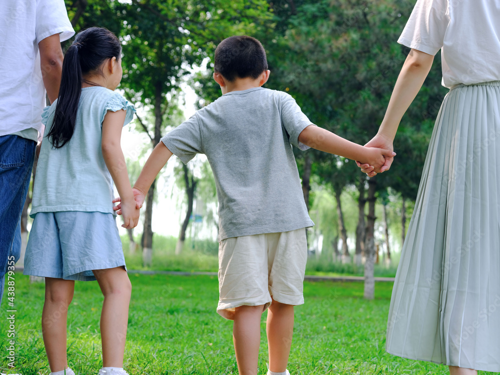 Happy family of four playing in the park