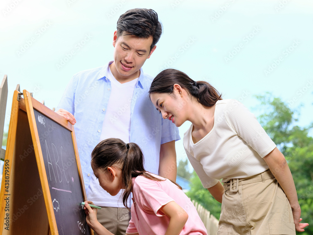 Happy family of three painting in the park