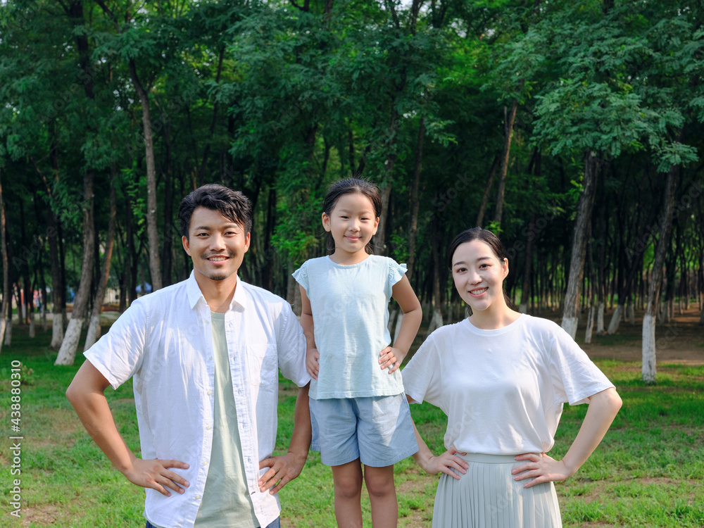 Happy family of three playing in the park