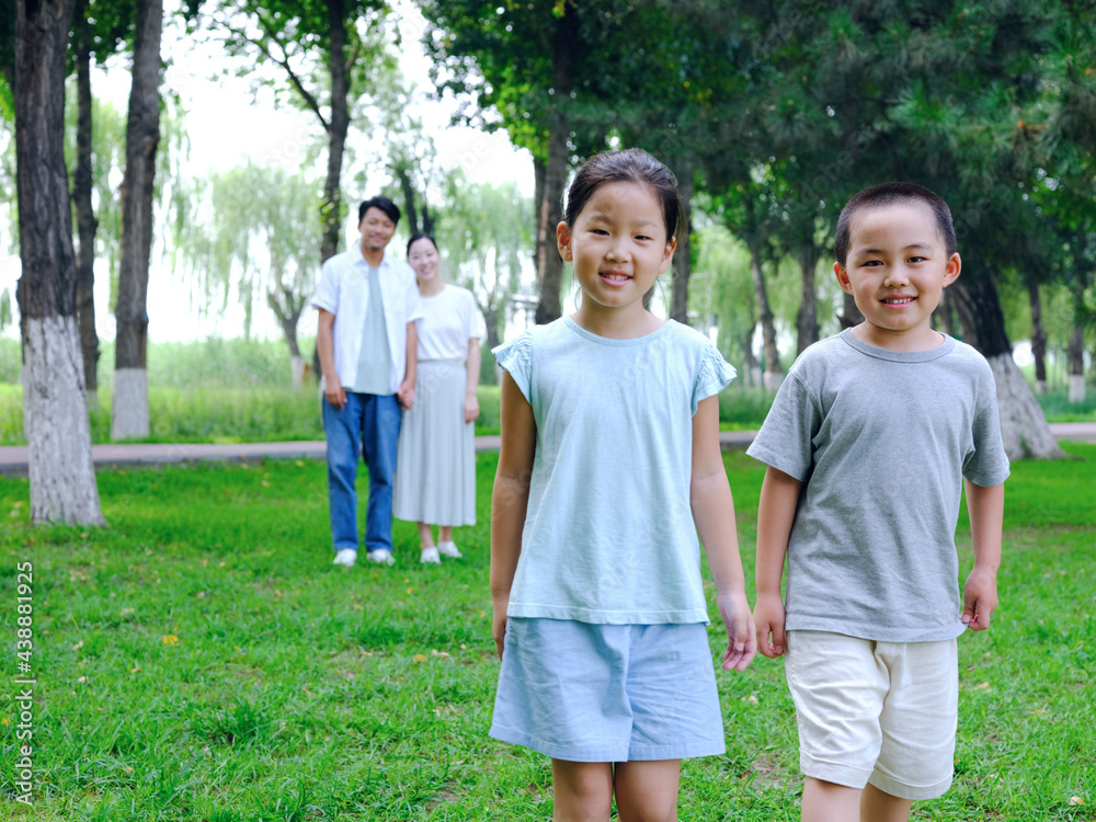 Happy family of four playing in the park