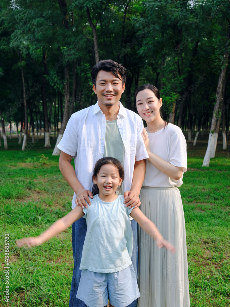 Happy family of three playing in the park