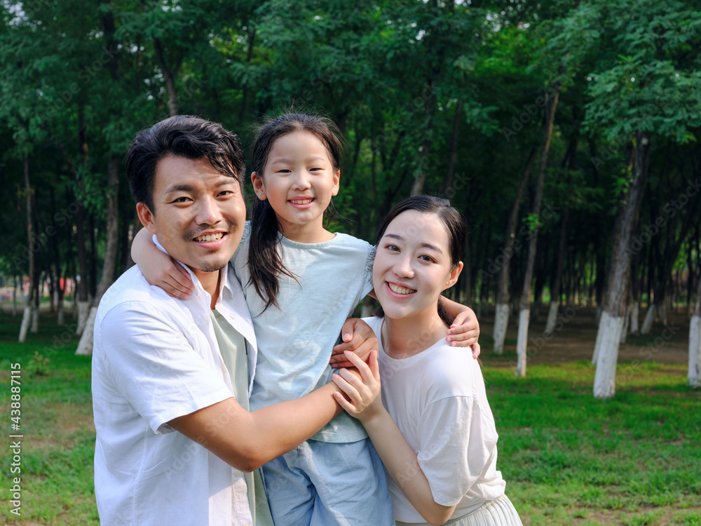 Happy family of three playing in the park