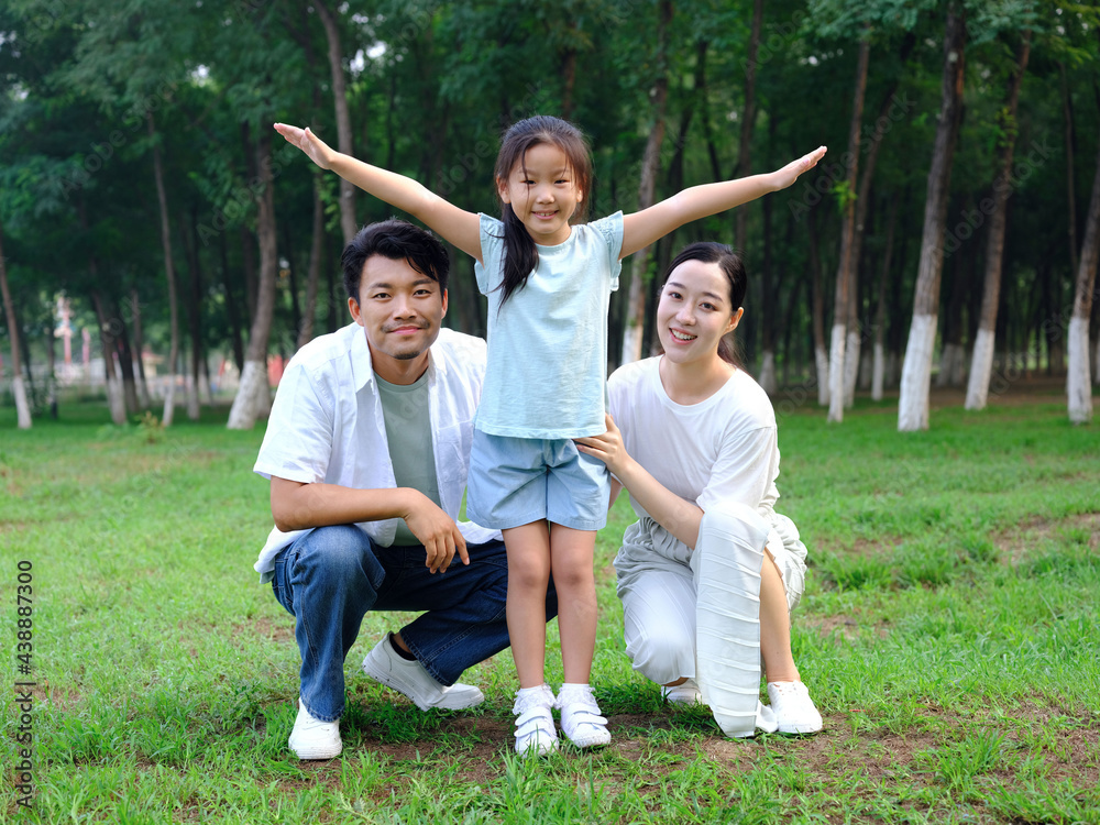 Happy family of three playing in the park