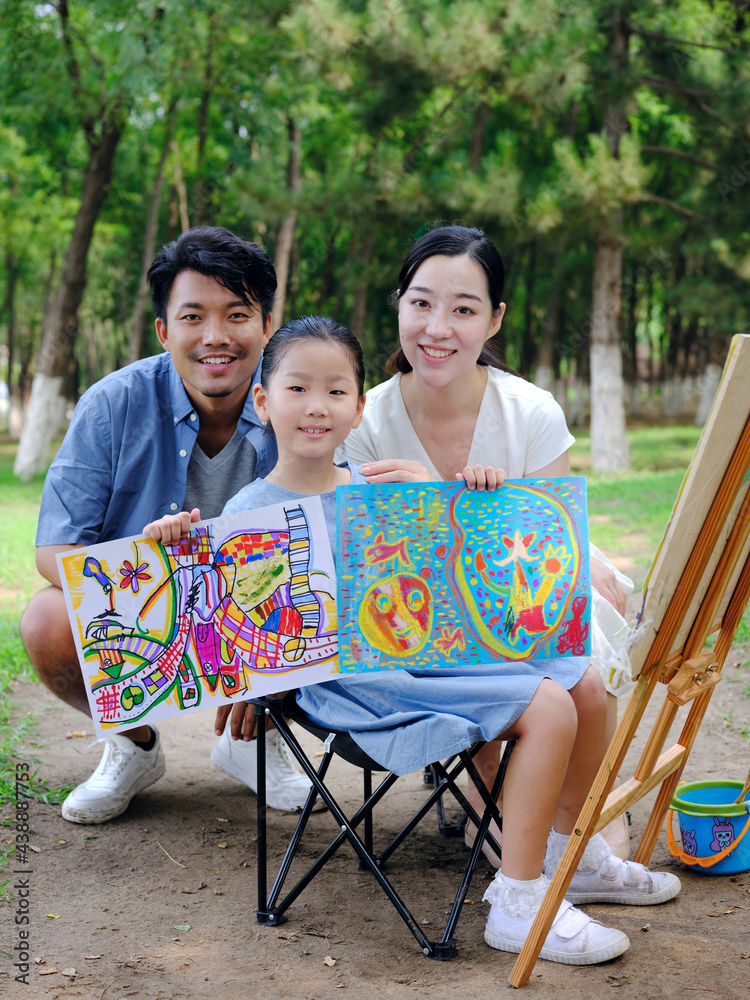 A happy family of three painting outdoors