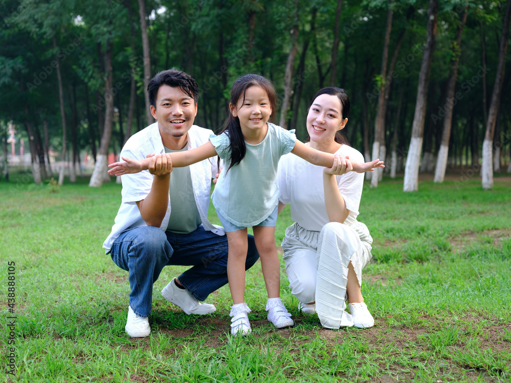 Happy family of three playing in the park