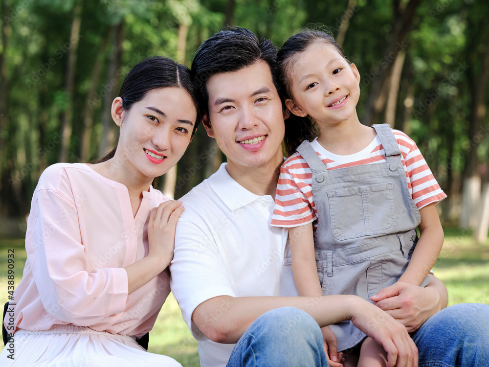 Happy family of three playing in the park