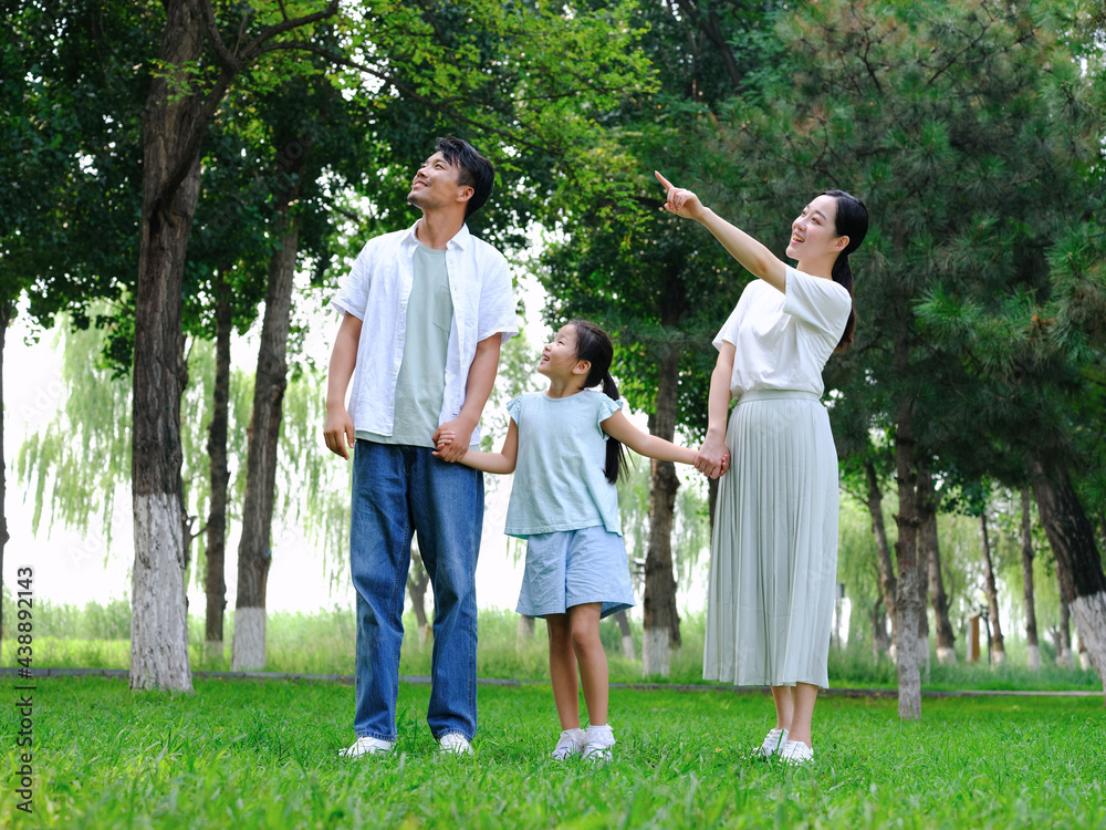 Happy family of three playing in the park