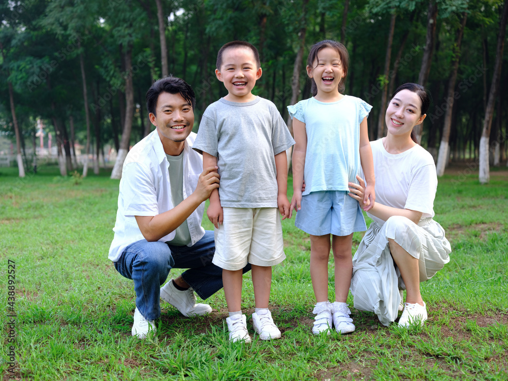 Happy family of four playing in the park