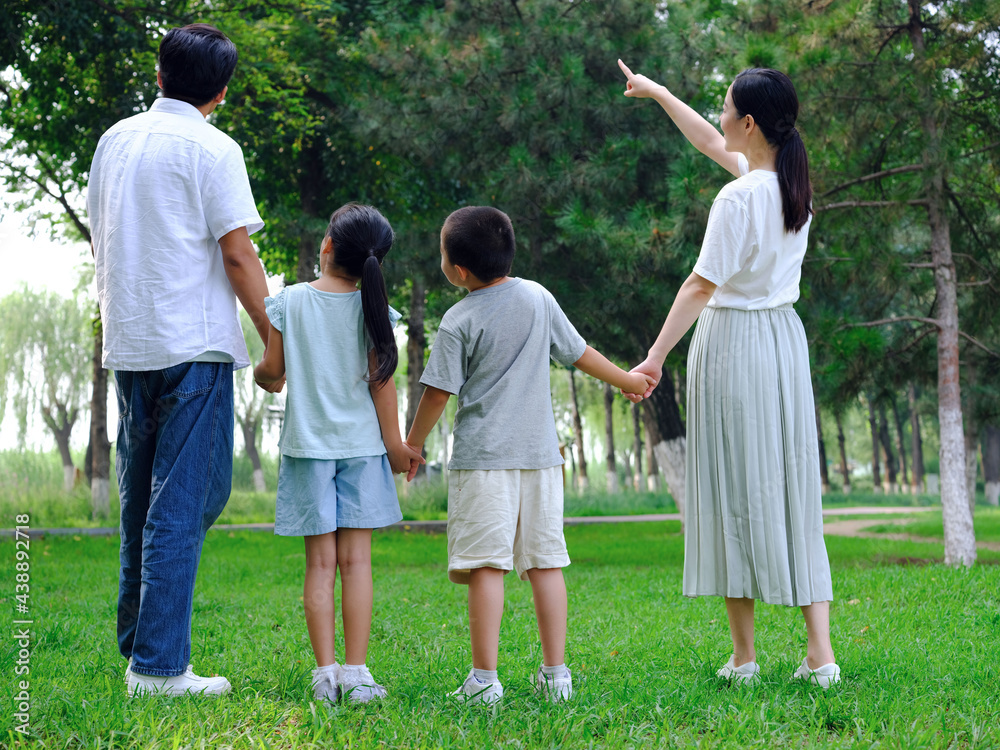 Happy family of four playing in the park