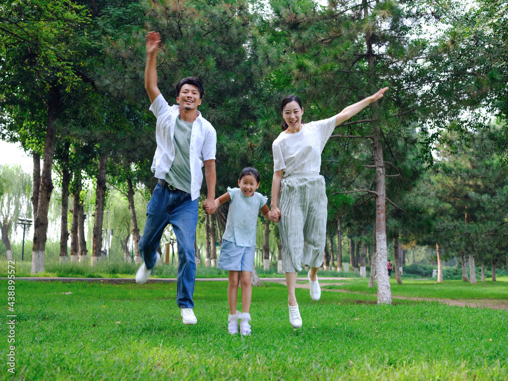 Happy family of three playing in the park