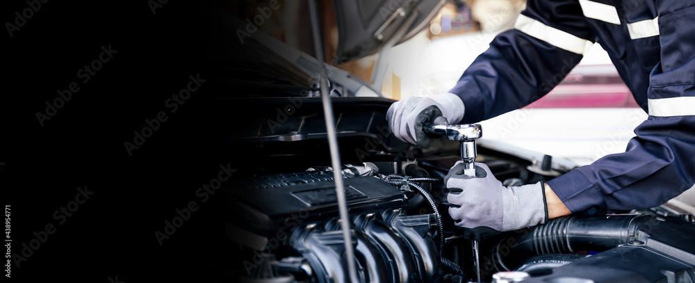 Professional mechanic working on the engine of the car in the garage. Car repair service. The concep